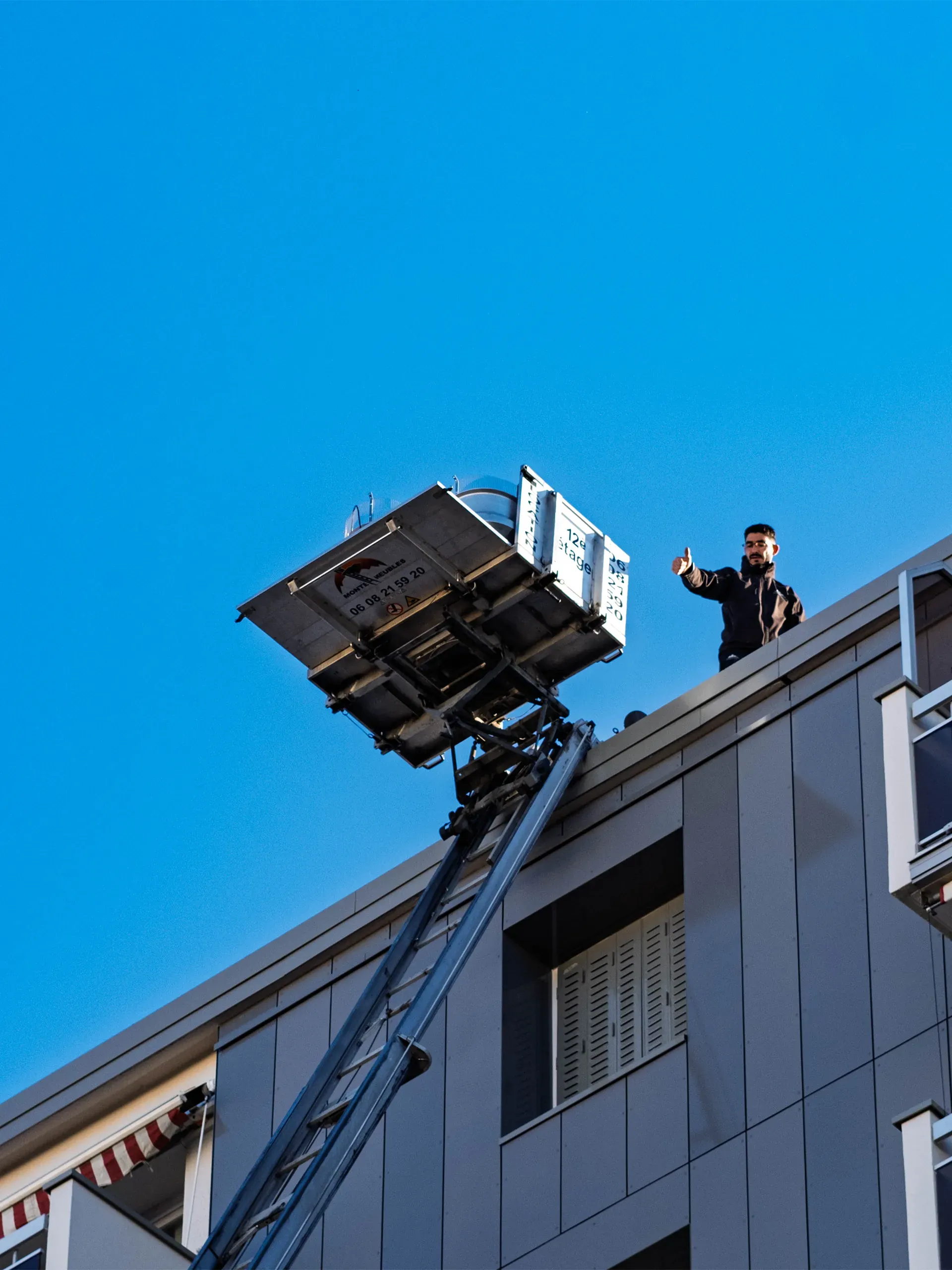 Monte-meubles montant jusqu'au toit d'un immeuble à Lyon